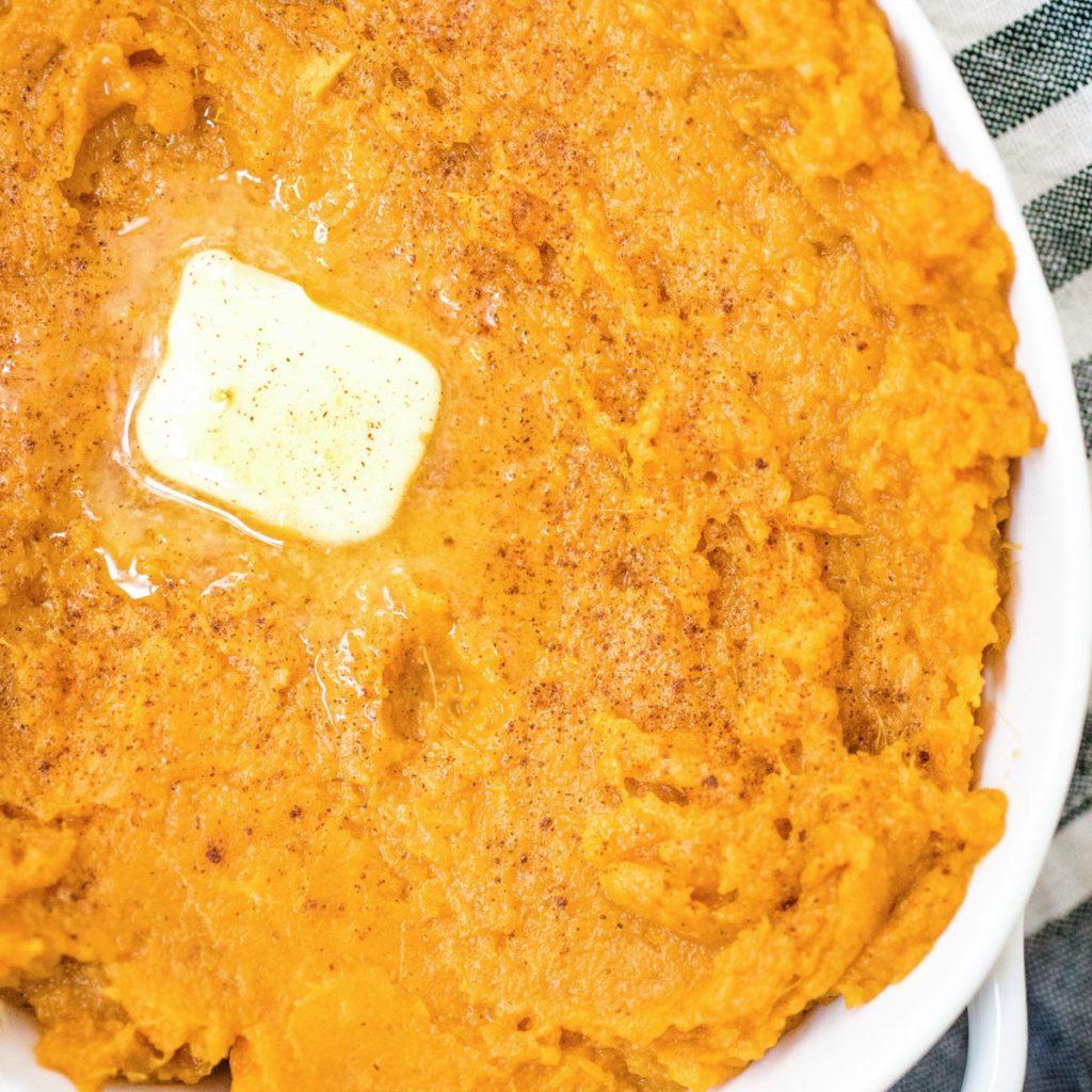 Ricette Instant Pot per il Ringraziamento 7 Purè di patate dolci in una pirofila bianca guarnito con burro