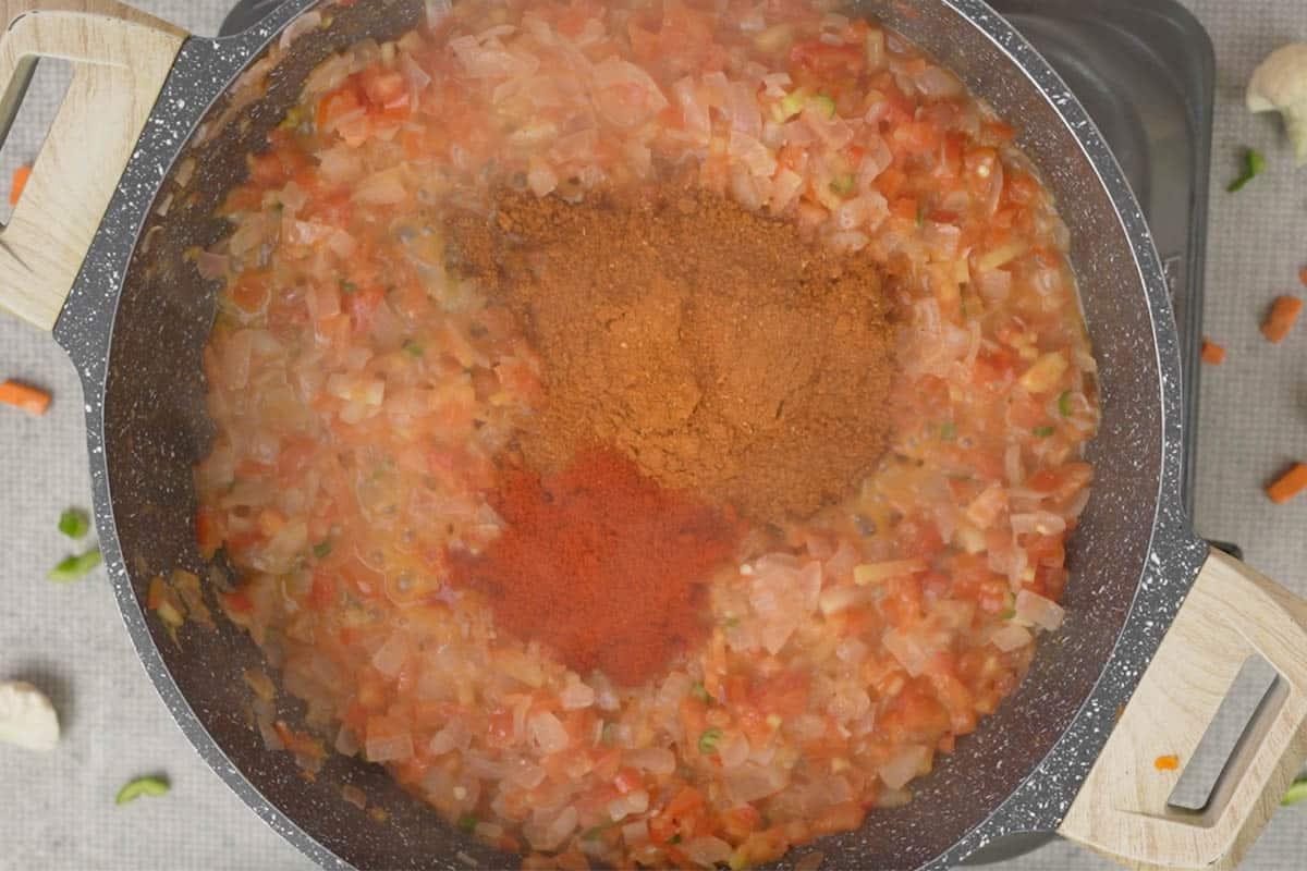 Peperoncino in polvere e pav bhaji masala aggiunti alla padella, mentre le spezie si tostano.