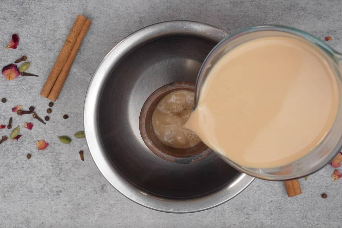 Tandoori Chai (Kulhad Chai) 8 Pentola di argilla calda tenuta in una pentola profonda e tè versato.