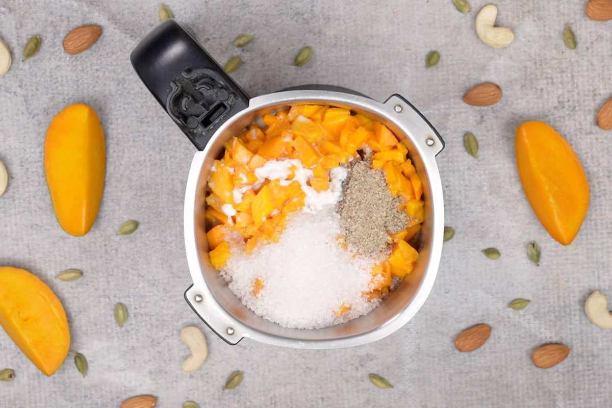 Aamras 8 Tutti gli ingredienti per l'Aamras aggiunti al frullatore, pronti per essere frullati.