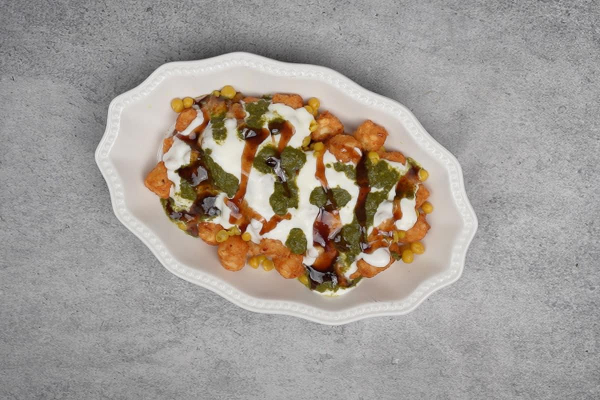 Tater tots guarniti con chutney di coriandolo e menta e chutney di tamarindo.