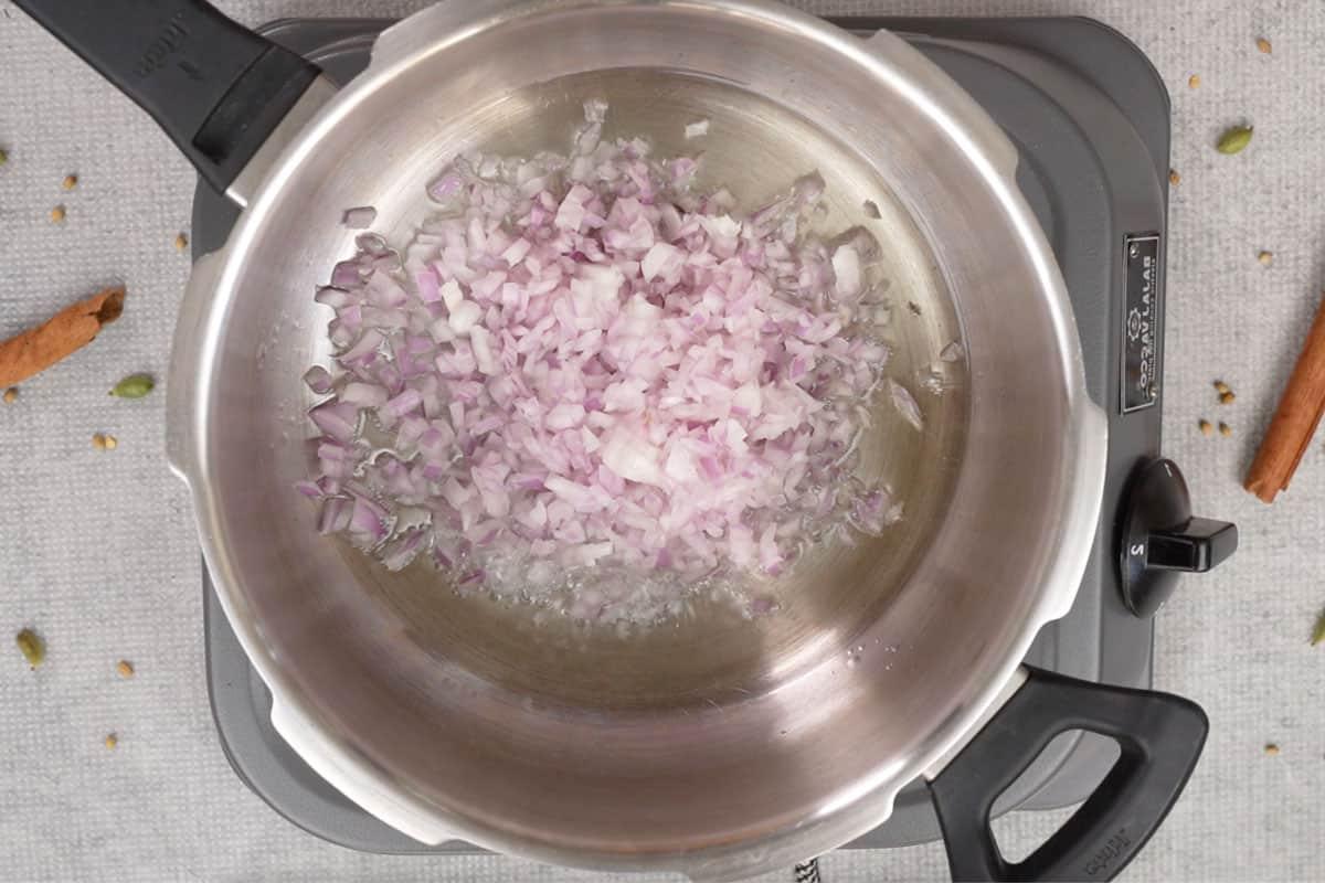 Cipolle tritate aggiunte alla pentola a pressione.