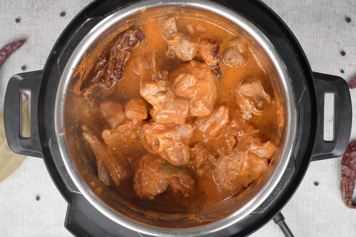 Rogan Josh di Montone 9 Acqua calda aggiunta alla pentola con il curry.