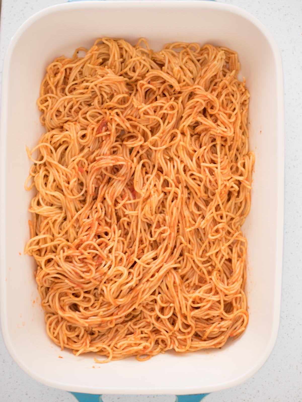 La Migliore Ricetta di Spaghetti al Forno (Facile) 9 Primo strato di spaghetti conditi in una teglia da forno, la base della pietanza