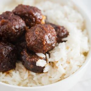Polpette a Cottura Lenta con Gelatina d'Uva e Salsa Chili 9 Polpette su riso in una ciotola bianca