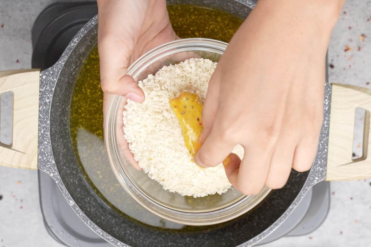 Impana i bastoncini di pesce ricoperti di pastella con il pangrattato.