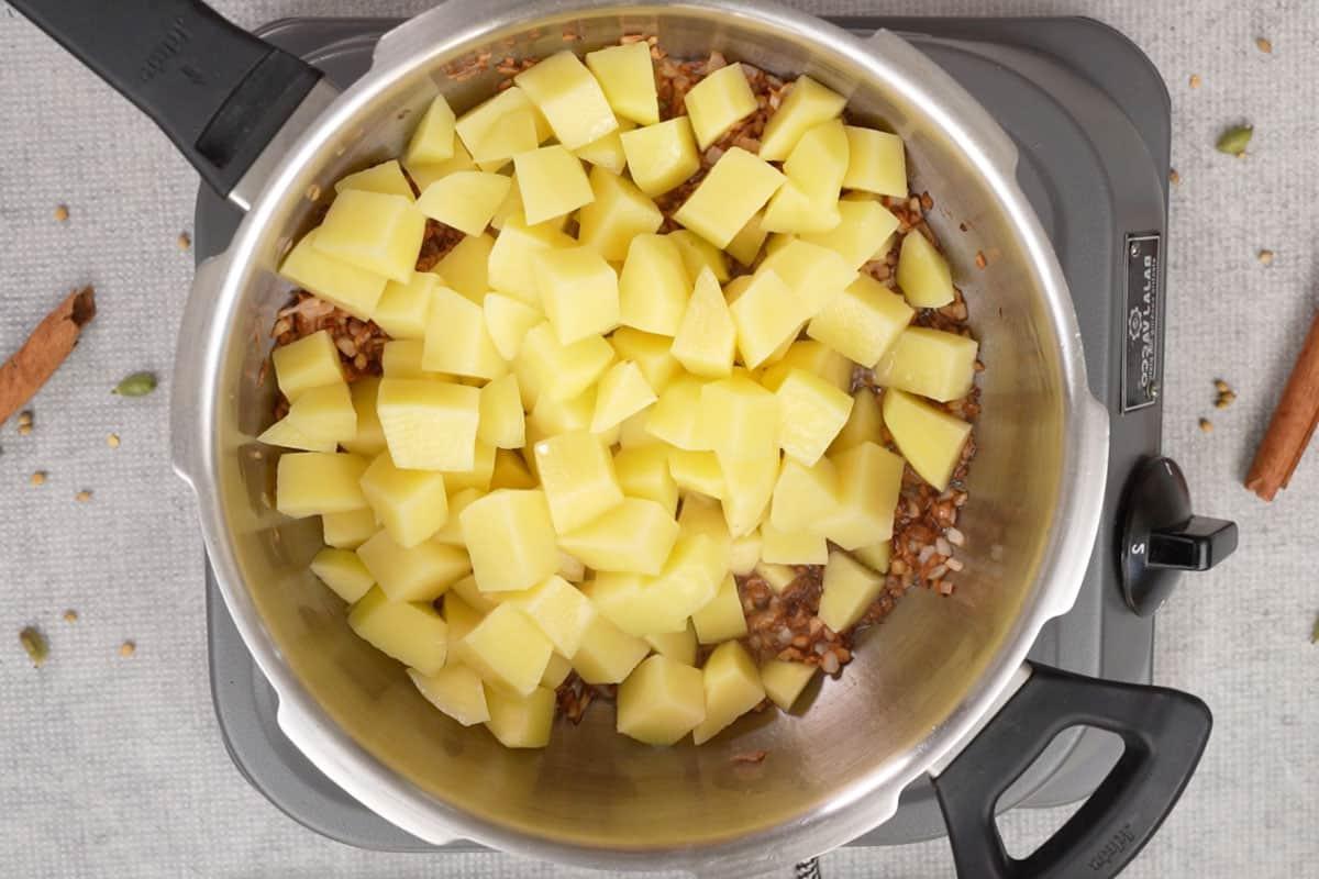 Cubetti di patate aggiunti alla pentola a pressione.