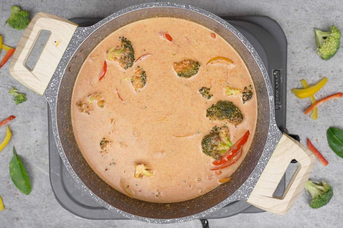 Salmone al Curry Panang 10 Il processo di mescolatura accurata di tutti gli ingredienti nella padella per unire i sapori del curry Panang.