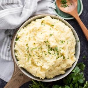 Purè di patate al Boursin 10 Ciotola di servizio di purè di patate al Boursin con un cucchiaio di legno accanto.