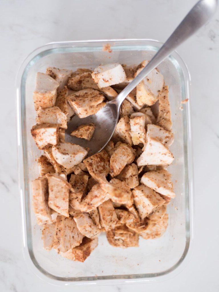 Sformato di Pollo Tex-Mex, Fagioli Neri e Riso 10 Pollo sfilacciato a cubetti, uniformemente ricoperto di condimento per taco, pronto per essere aggiunto alla teglia.