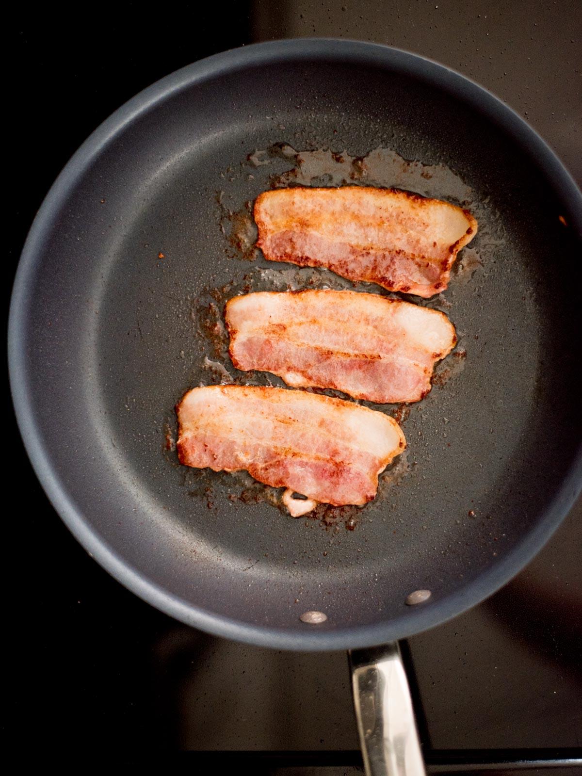 Patate Doppia Cottura in Friggitrice ad Aria 10 Pancetta che frigge in una padella.