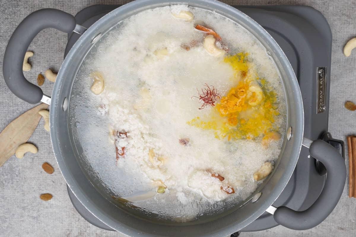 Acqua, zucchero, curcuma in polvere e zafferano aggiunti alla padella.