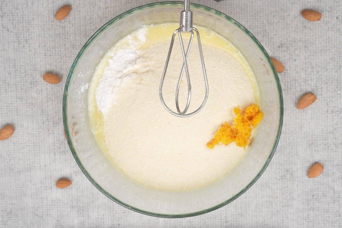 Basbousa (Torta Medio-Orientale di Semolino e Cocco) 10 Estratto di vaniglia, farina, semolino, cocco, scorza d'arancia e lievito in polvere aggiunti alla ciotola.