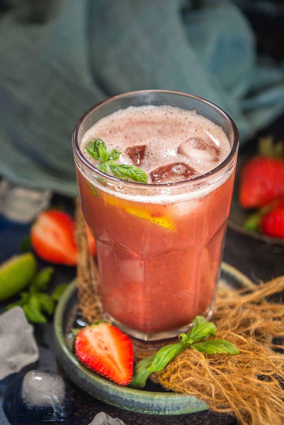 Limonata alla Fragola e Basilico 2 Limonata fragola e basilico servita in un bicchiere elegante.