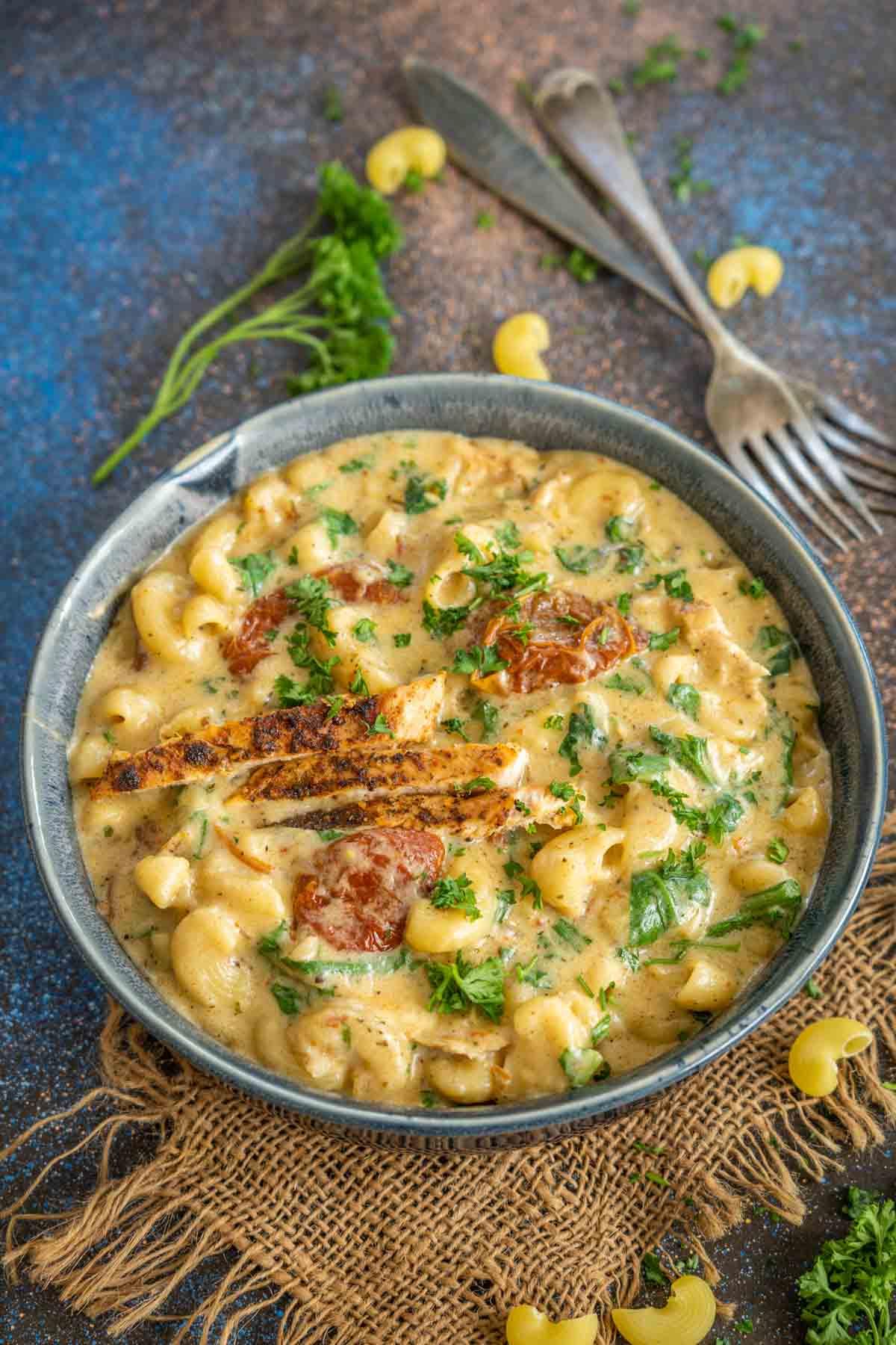 **Maccheroni al Formaggio al Pollo Toscano** 2 Una ciotola di Mac and Cheese con Pollo alla Toscana cremoso e fumante.