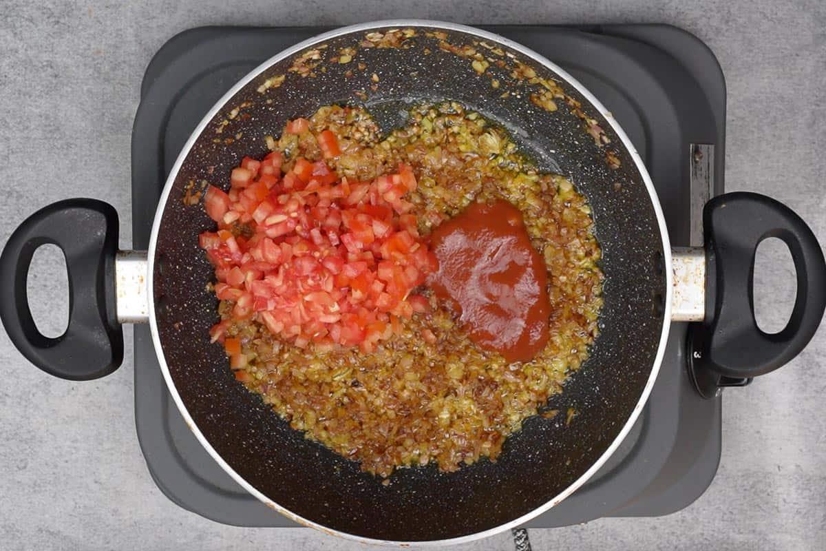 Punjabi Rajma Masala 11 Pomodori tritati e passata di pomodoro aggiunti alla padella.