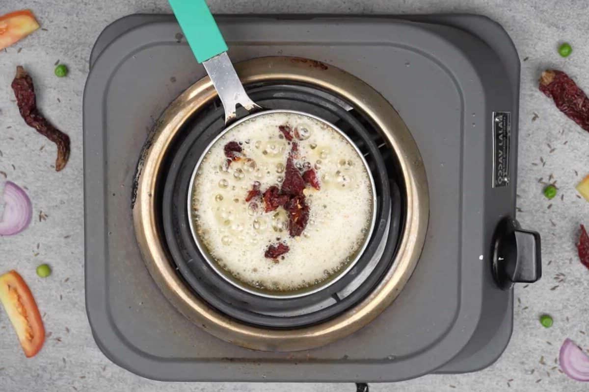 Maggi Tadka Formaggiosa 11 Peperoncini rossi secchi spezzati aggiunti alla padella per il tadka.