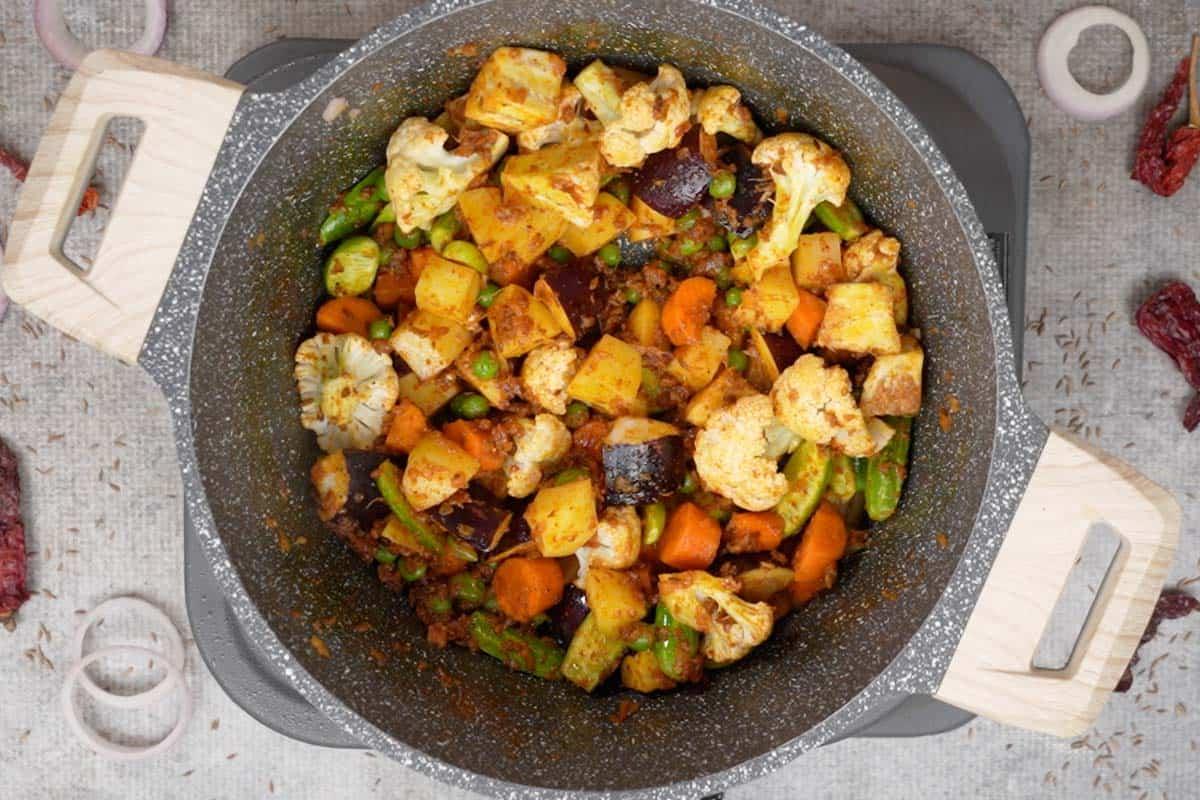 Verdure mescolate con il masala nella pentola.