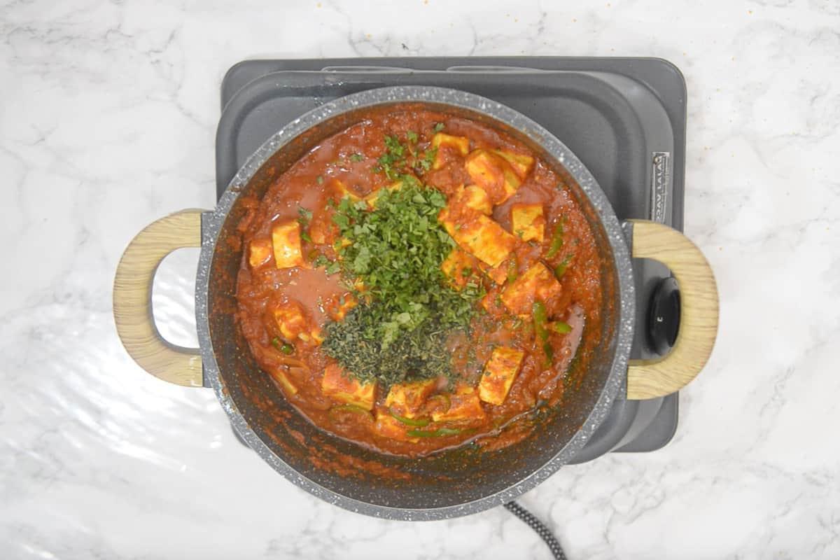 Paneer Jalfrezi 14 Kasuri methi, succo di limone e coriandolo fresco aggiunti nella padella.