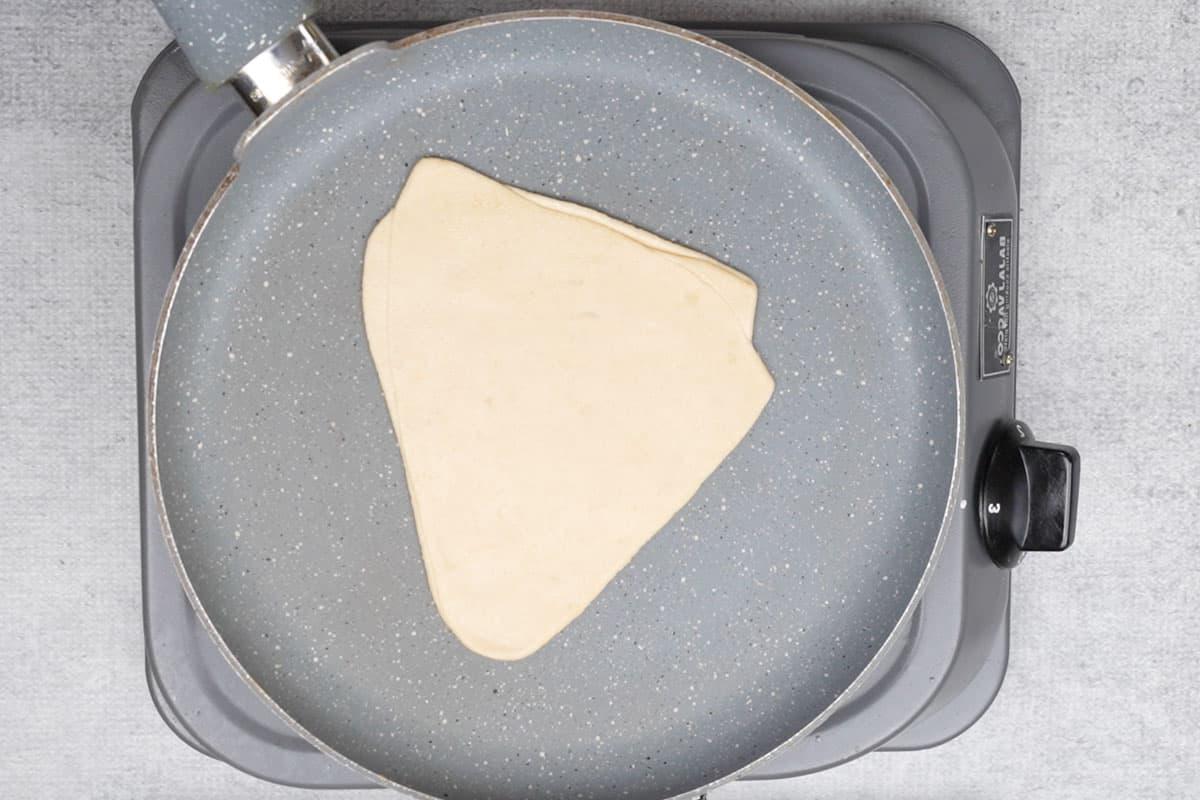 Paratha trasferito su una piastra calda.