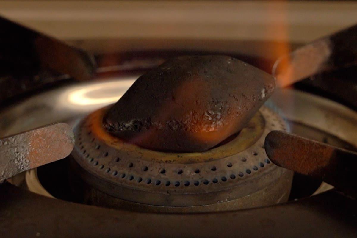 Pollo Angara 15 Charcoal heating in a pan.