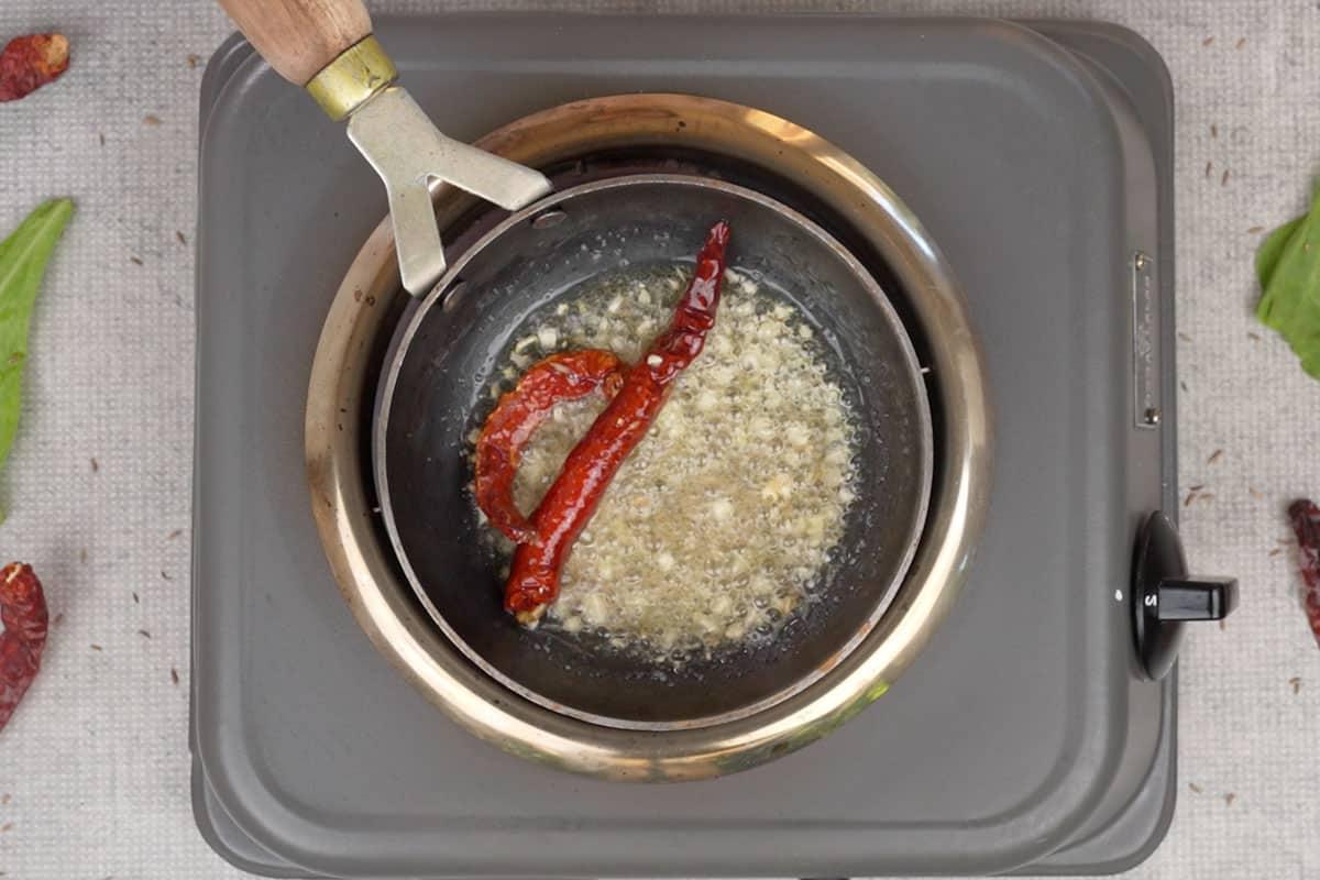 Curry di Spinaci e Mais 15 Aglio, peperoncini secchi, asafetida e semi di cumino aggiunti al ghee caldo.