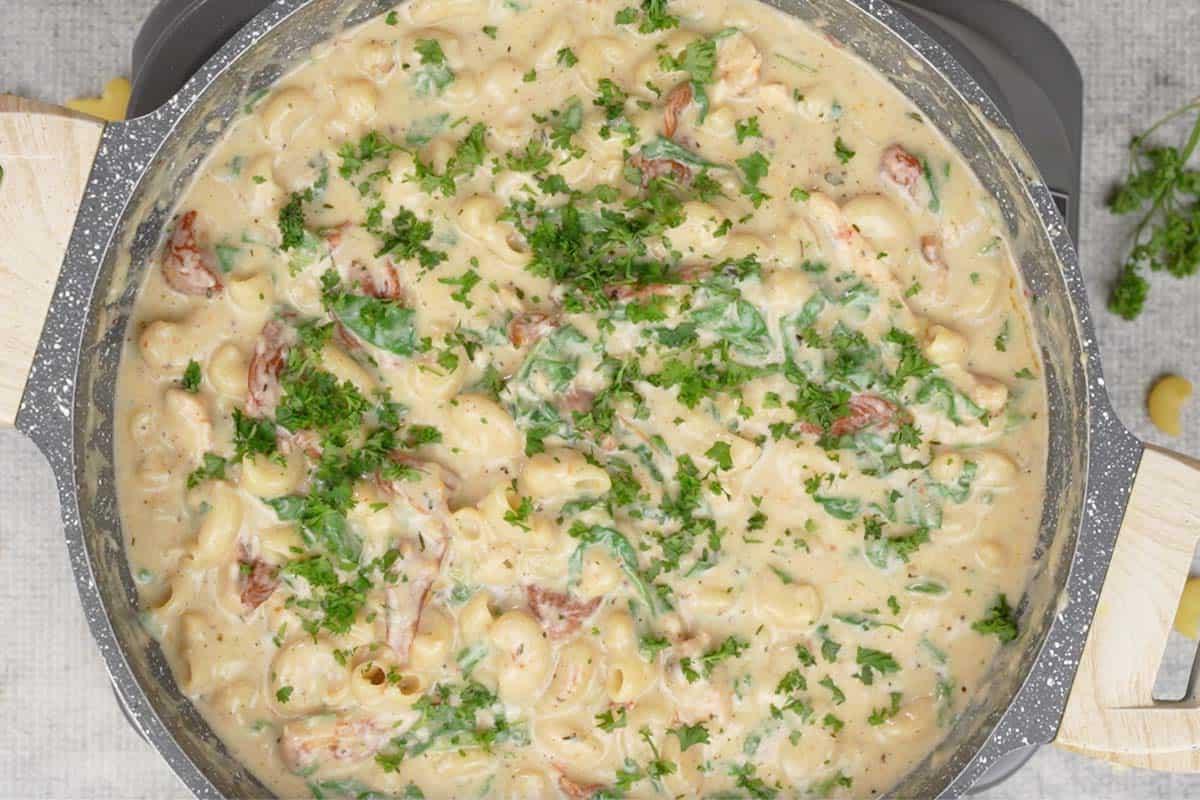 **Maccheroni al Formaggio al Pollo Toscano** 16 Mac and Cheese con Pollo alla Toscana pronto, guarnito con prezzemolo tritato.
