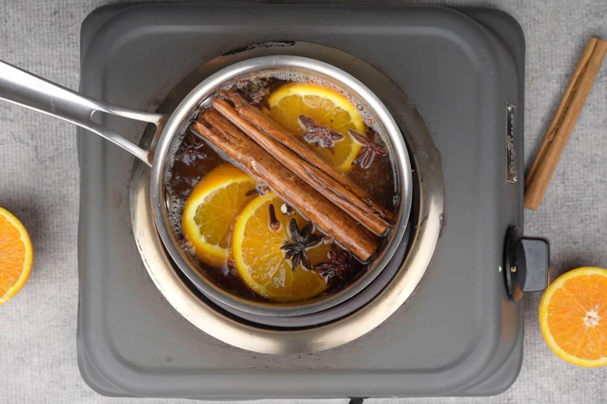 Tutti gli ingredienti eccetto il rum che sobbollono in un pentolino.