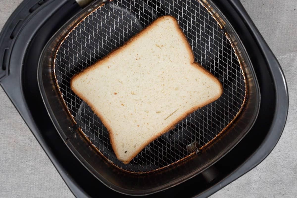 Bread slice placed in the air fryer.