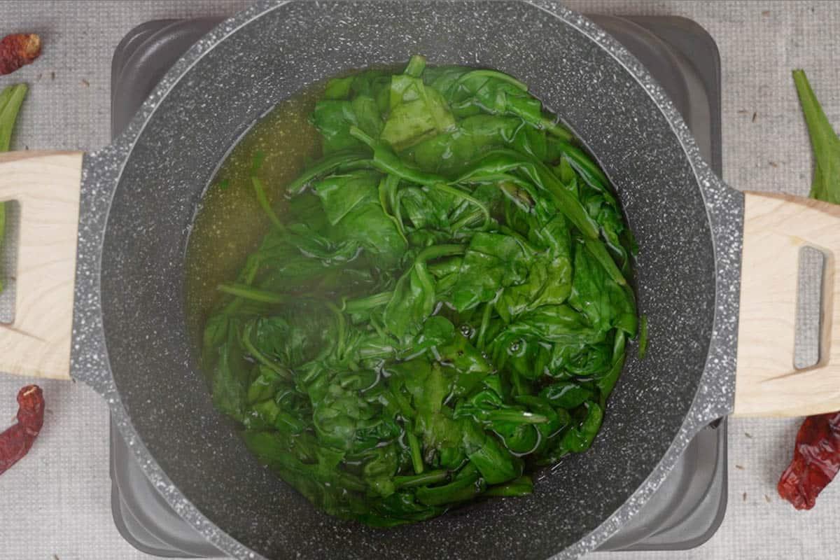 Curry di Spinaci e Mais 3 Bicarbonato di sodio e spinaci aggiunti all'acqua bollente in una pentola.