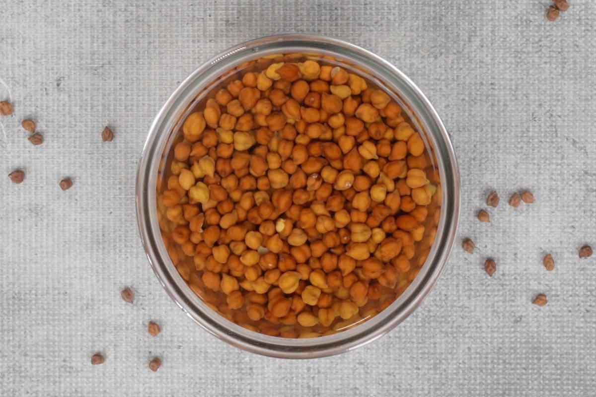 Curry di ceci 3 Ceci Kala Chana messi in ammollo in una ciotola, pronti per la cottura.