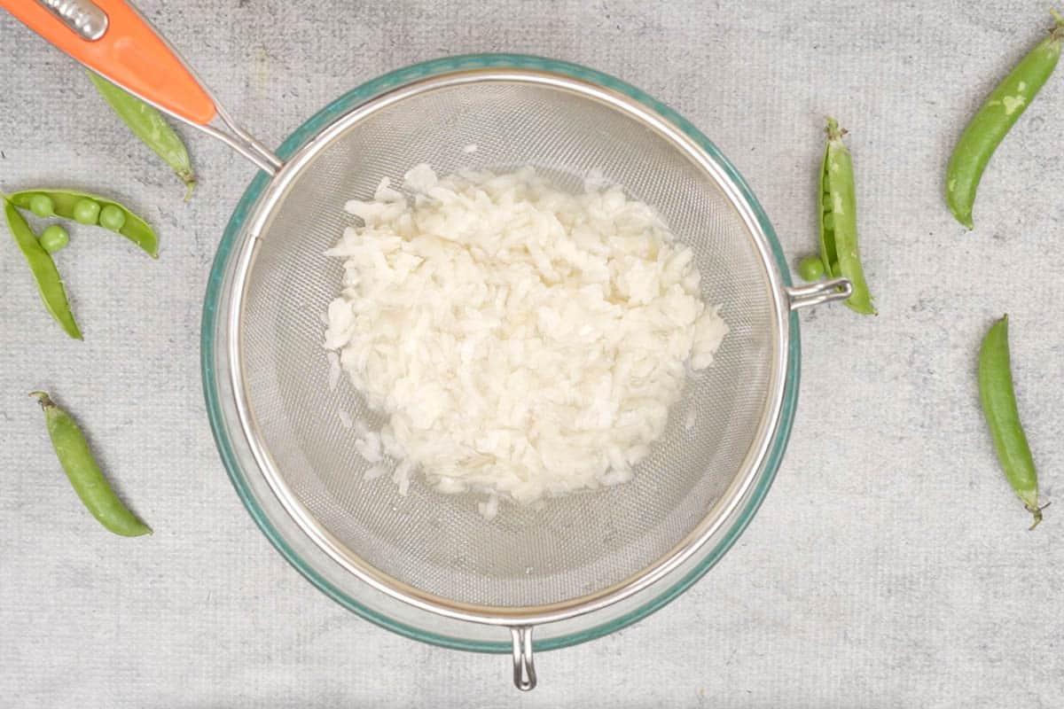Fiocchi di riso e piselli 3 Poha sciacquato in un colino.