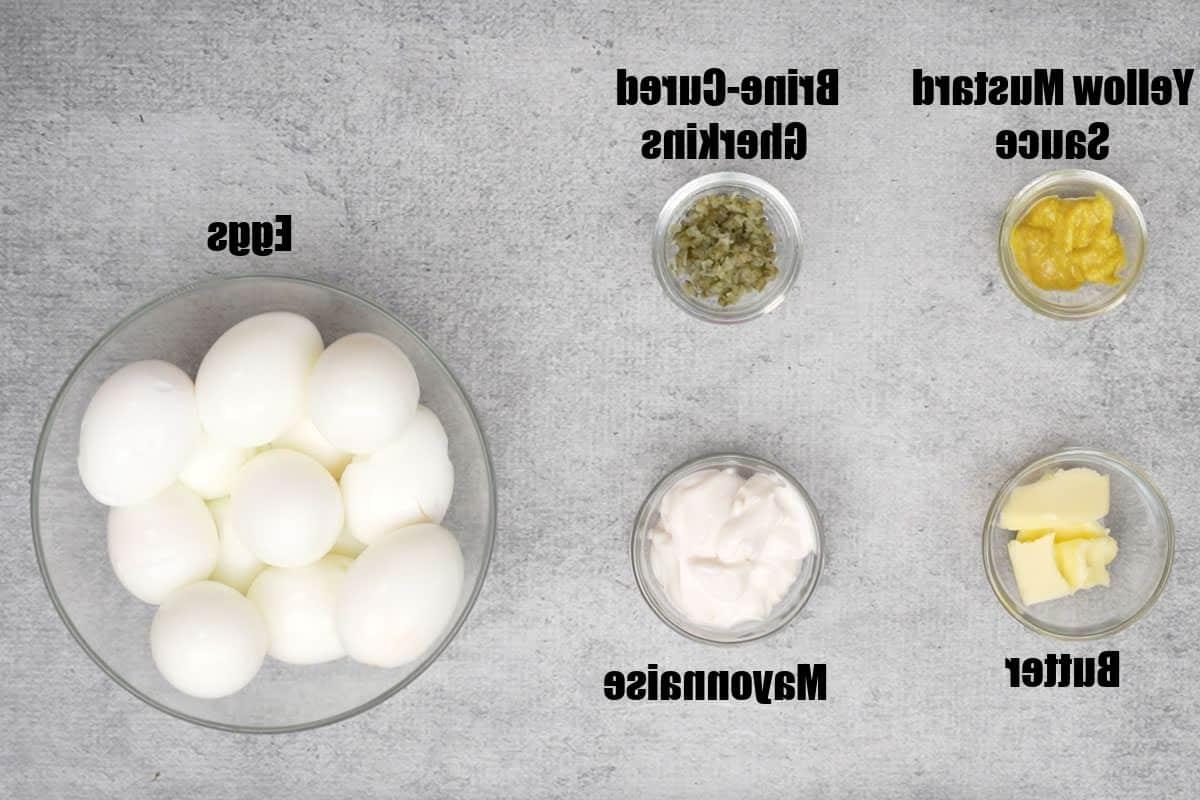 Ingredienti per le uova alla diavola milionarie: senape, burro, cetriolini, maionese e uova sode.