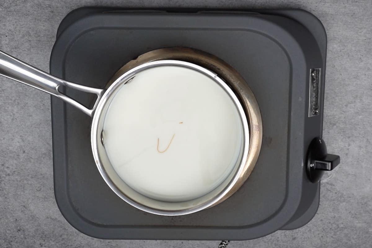 Latte, zucchero e sciroppo di caramello aggiunti in una padella.