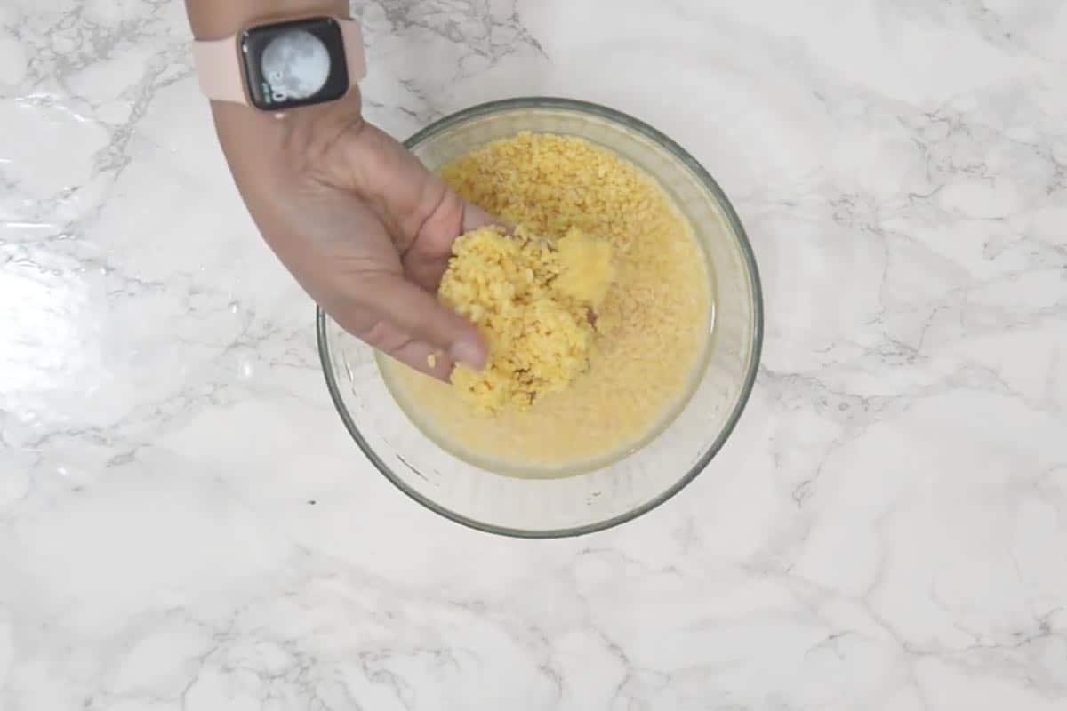 Halwa di Moong Dal 4 Lenticchie mung in ammollo in acqua in una ciotola di vetro.