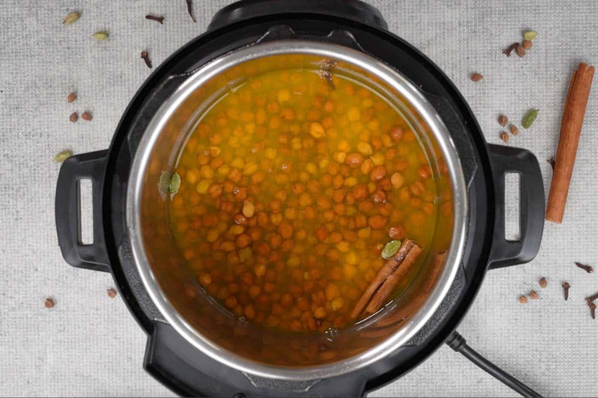 Curry di ceci 4 Ceci in ammollo, acqua, sale, curcuma in polvere e spezie intere aggiunti a una Instant Pot.