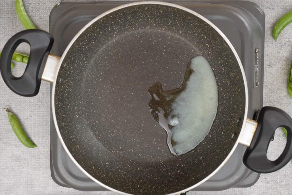Fiocchi di riso e piselli 4 Ghee che si scalda in padella.