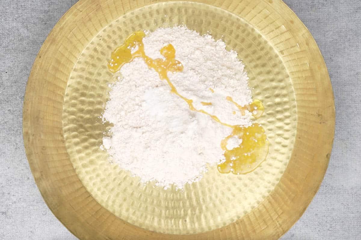 Farina, sale e olio aggiunti a una grande ciotola.
