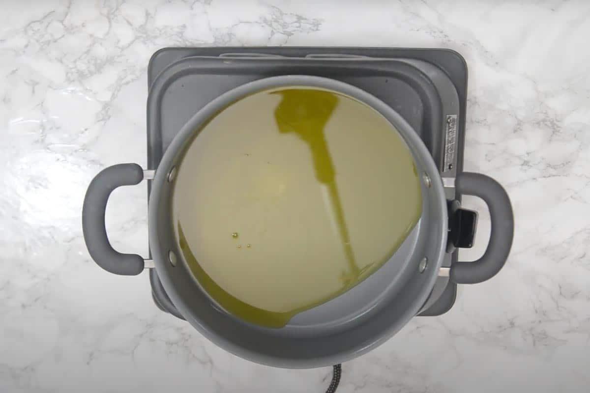Halwa di Moong Dal 6 Ghee che si scioglie e si scalda in una padella antiaderente su un fornello.