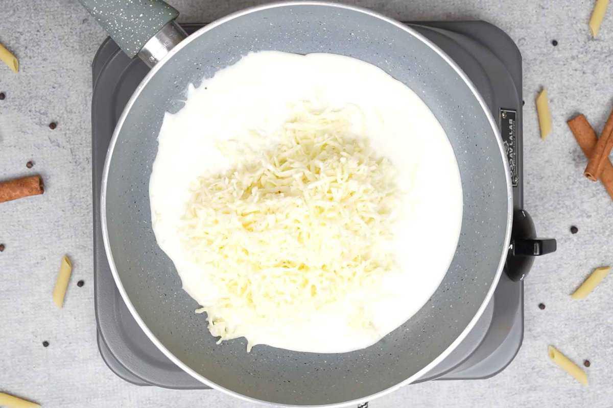 Outback Mac and Cheese 7 Formaggio e panna aggiunti a una padella.