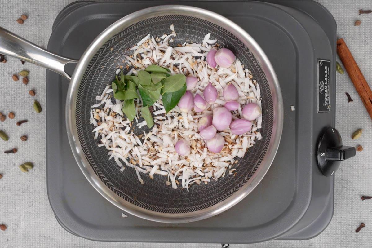 Curry di ceci 7 Scalogni e foglie di curry aggiunti alla padella con il cocco tostato.
