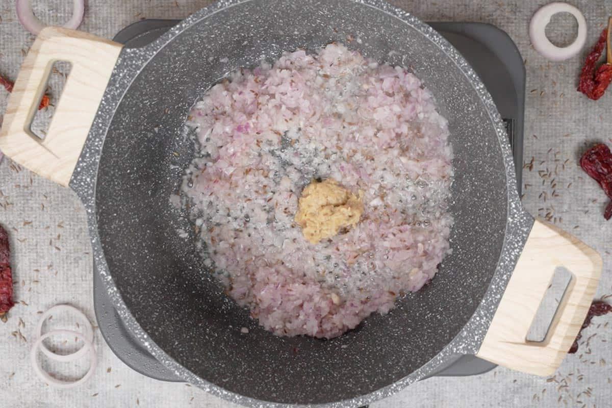 Pasta di zenzero e aglio aggiunta alla pentola.