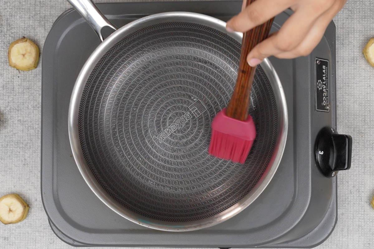 Pancakes di Ragi e Banana 9 Spennellare una padella con olio.