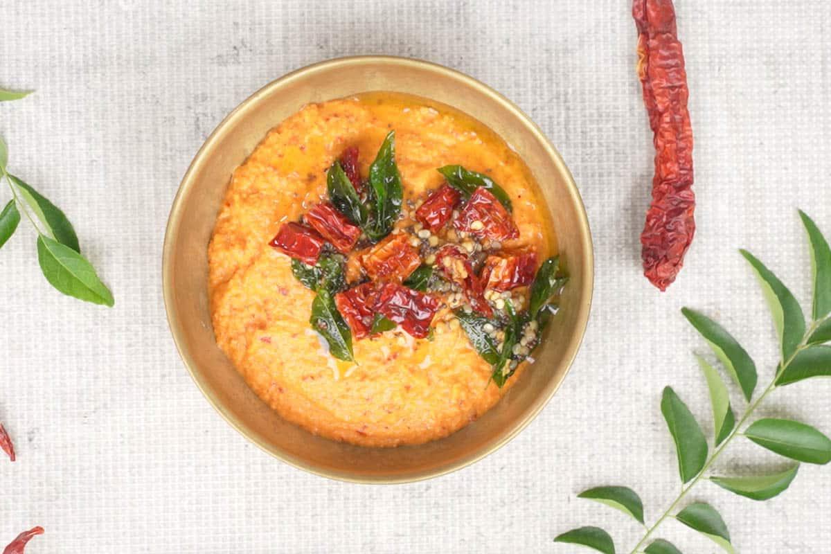 Chutney di Pomodoro e Cocco 9 Il tempering caldo e aromatico viene versato sopra il chutney di pomodoro e cocco già frullato, pronto per essere mescolato e servito, aggiungendo un tocco finale di sapore e texture.