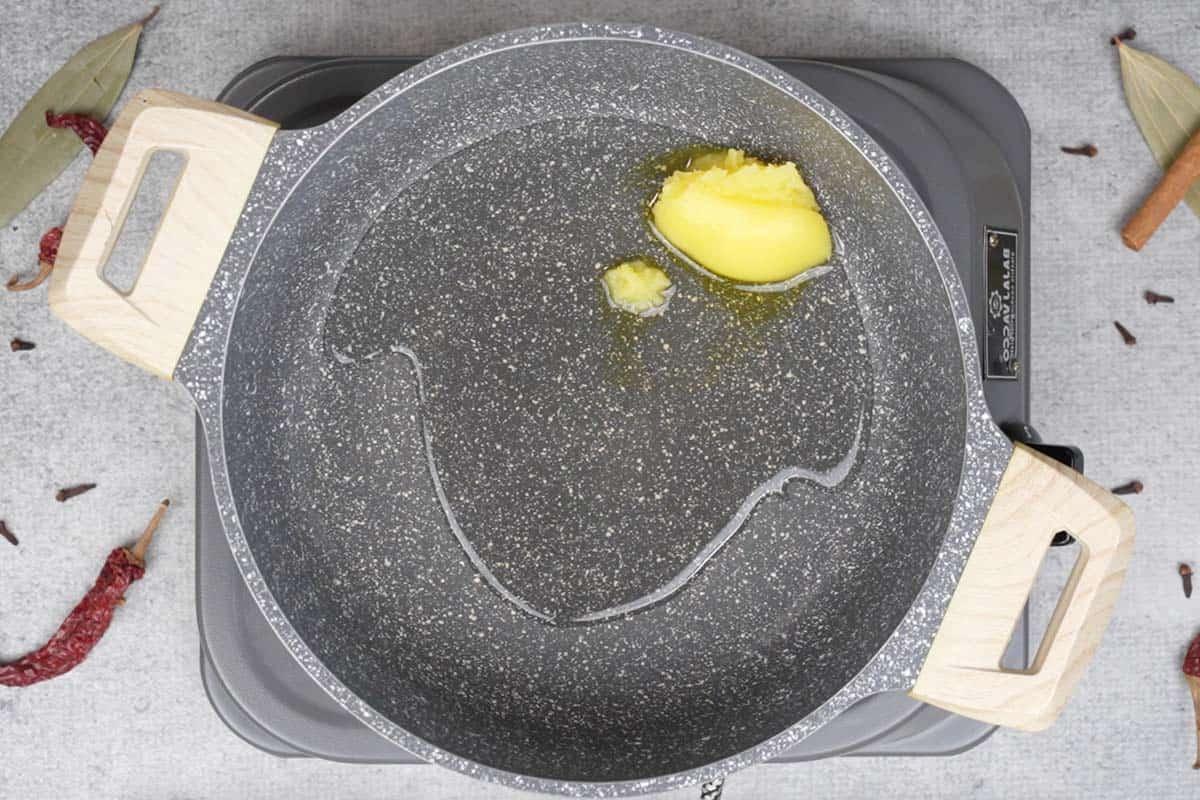 Pollo Angara 9 Ghee and oil heating in a pan.