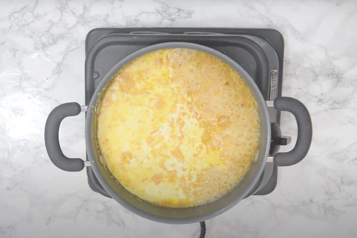 Halwa di Moong Dal 9 Latte intero aggiunto nella padella con le lenticchie fritte, mentre si cuoce e viene assorbito.