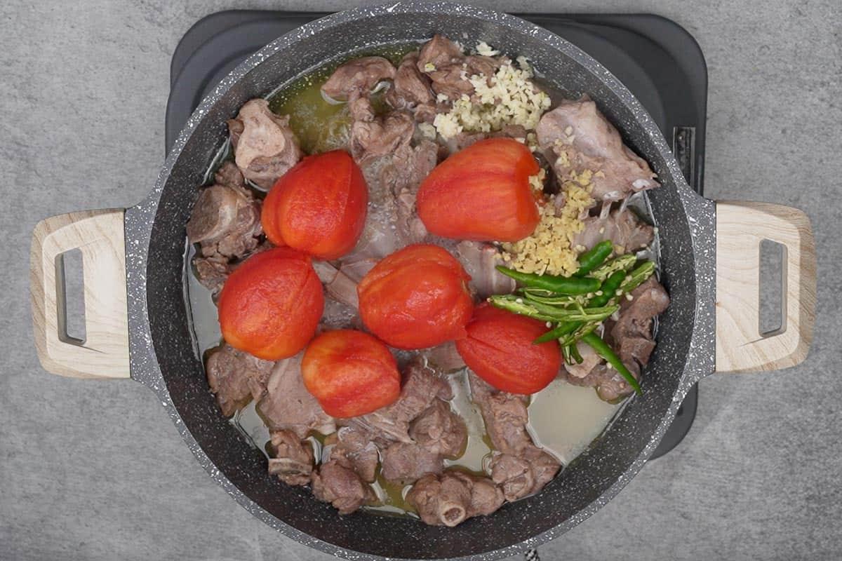 Kadhai di Carne Peshawari 10 Pomodori pelati, peperoncini verdi, zenzero e aglio aggiunti nella padella.