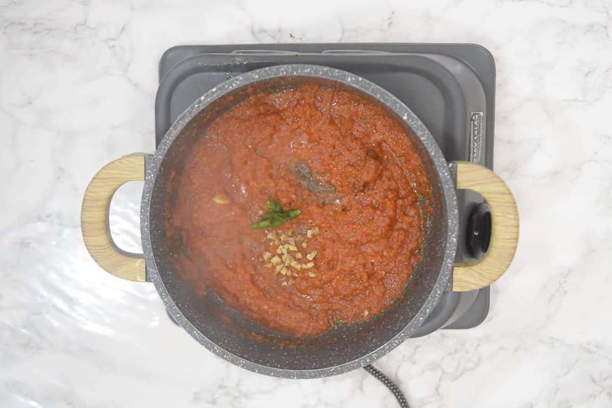 Paneer Jalfrezi 10 Peperoncino verde e zenzero tritato aggiunti nella padella, pronti per cuocere insieme alla salsa.