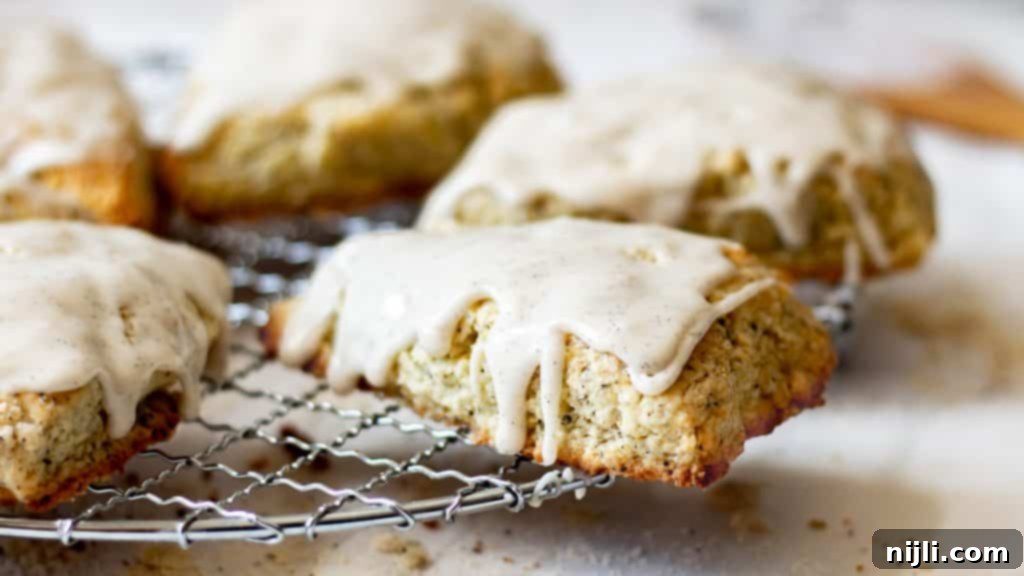Aromatic Earl Grey Scones with Vanilla Bean Glaze 4 Earl Grey Scones on a wire rack drizzled with vanilla bean glaze