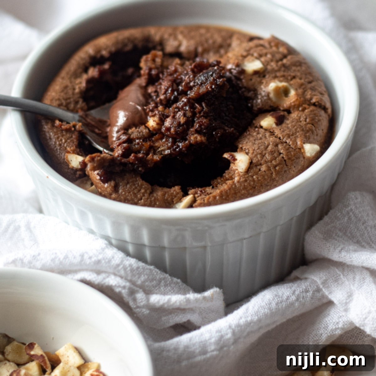 Indulgent Nutella Baked Oats 2 bowl of nutella baked oats with hazelnuts on top